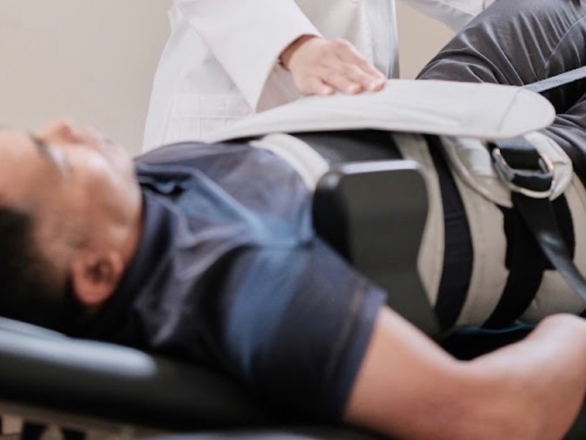 Patient secured in a pelvic harness on the computerized spinal decompression table