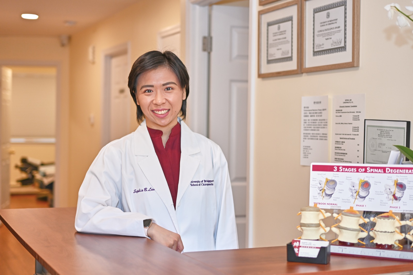 Dr. Sophia Lam, D.C. at the front desk of her Bayside, NY clinic